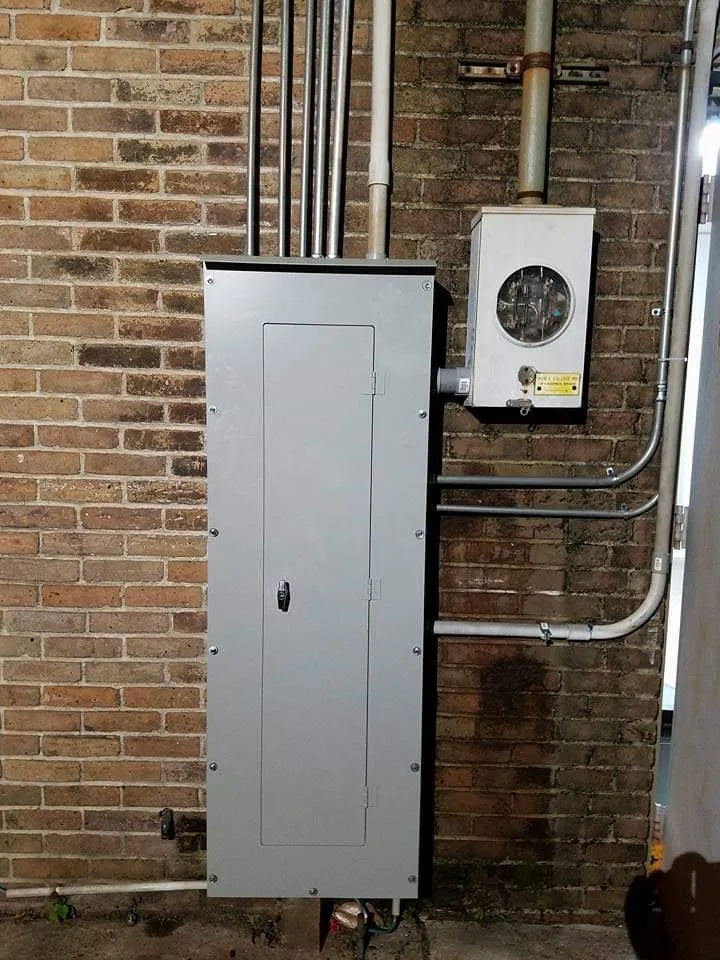 New breaker panel and meter can mounted on a brick wall