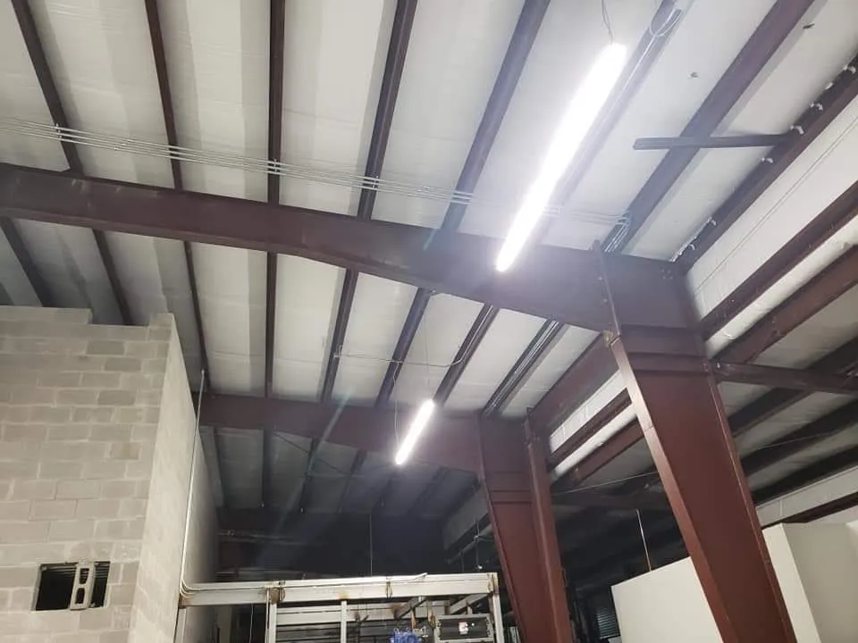High-bay LED fixtures and conduit in a commercial ceiling