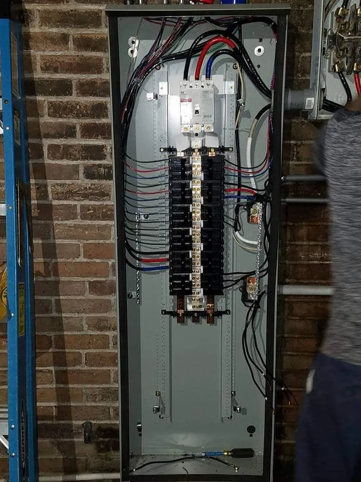 Open breaker panel with labeled circuits during a residential install